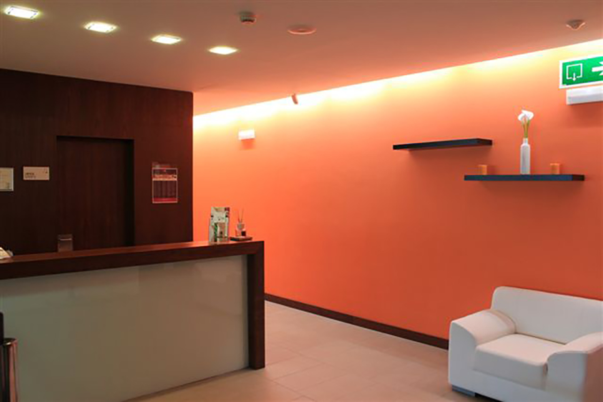 Recepción del Beauty & Spa, con la pared naranja y el mostrador